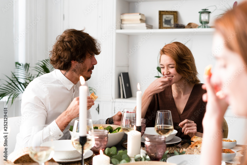 Friends having fun at a dinner party, enjoying eating together Friends having fun at a dinner party, enjoying eating together