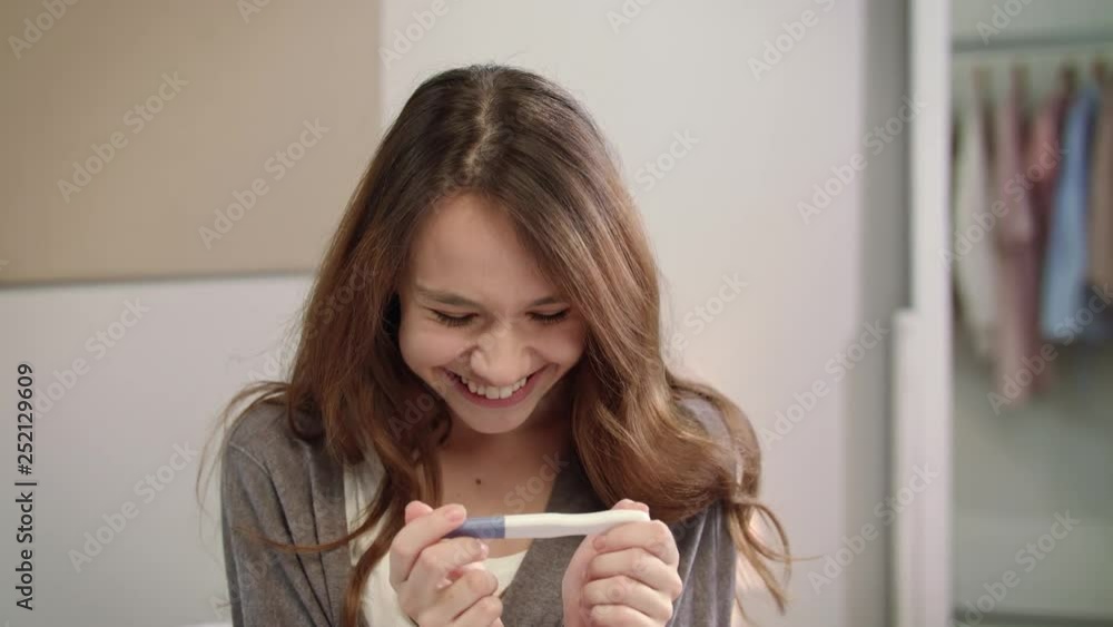 Shocked woman positive pregnancy test result. Portrait of pregnant woman test Shocked woman positive pregnancy test result. Portrait of pregnant woman test