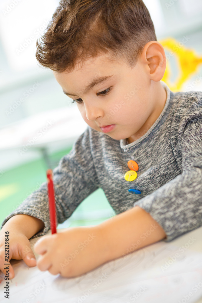 Cute young concentrated boy drawing at school Cute young concentrated boy drawing at school