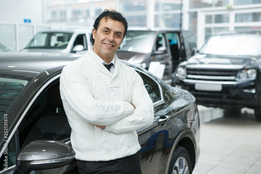 Mature man choosing a new car at the dealership salon Mature man choosing a new car at the dealership salon