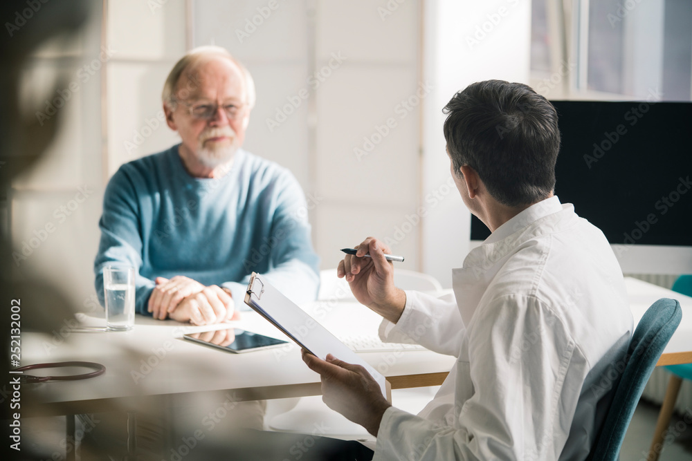 Doctor talking to senior patient in medical practice Doctor talking to senior patient in medical practice