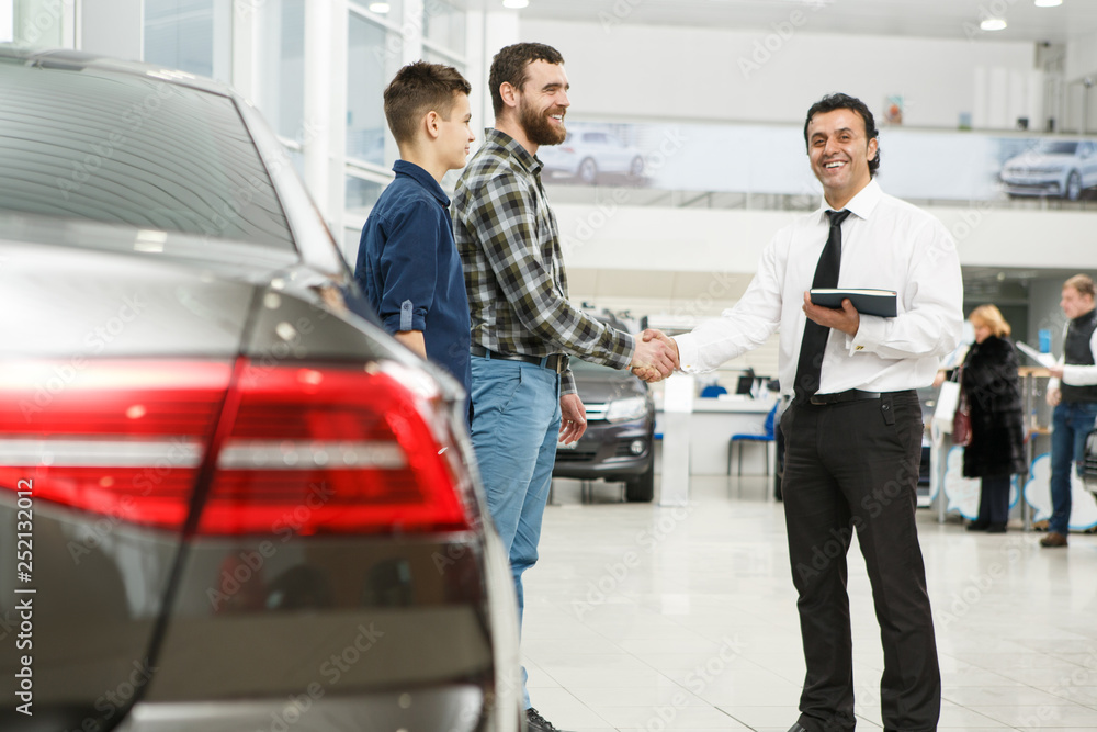 Handsome mature man and his son buying a new car Handsome mature man and his son buying a new car