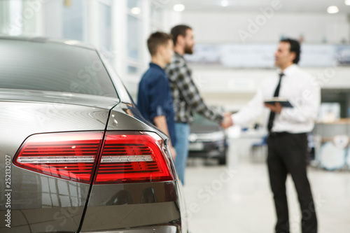 Handsome mature man and his son buying a new car