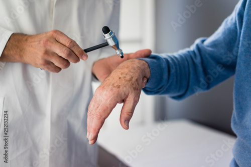 Close-up of doctor examining senior patient in medical practice