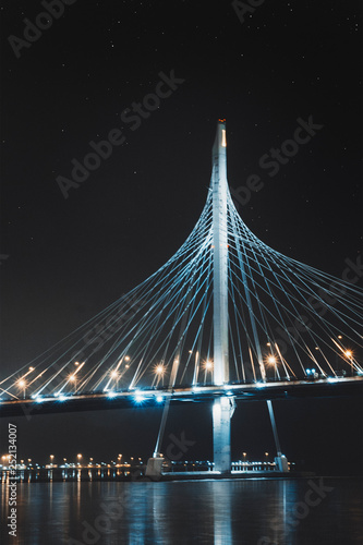 Beautiful cable-stayed bridge in St. Petersburg, Russia, with starry sky and cozy city lights