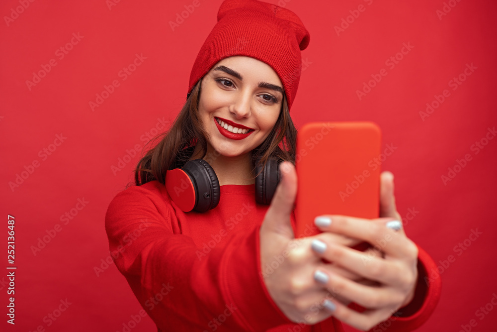 Naklejka premium Contemporary bright hipster girl taking selfie 