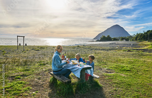 Chile, Chaiten, Carretera Austral, family having picnic at the beach photo