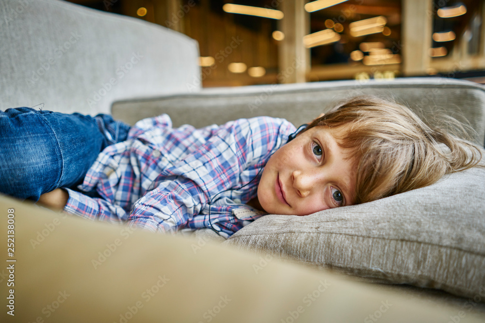 Portrait of boy lying on couch with earphones Portrait of boy lying on couch with earphones