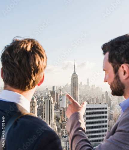 USA, New York City, two businessmen looking on cityscape on Rockefeller Center observation deck photo