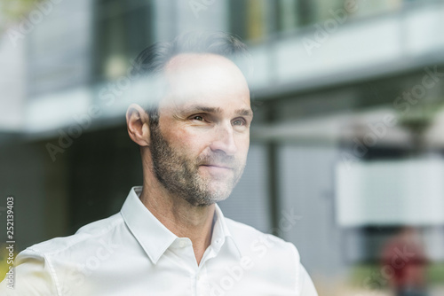 Portrait of smiling businessman looking out of window photo