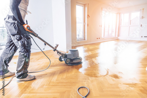 Obraz na płótnie Varnishing of oak parquet floor, workers  tool.