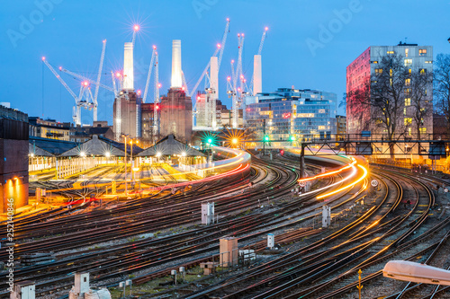 United Kingdom, England, London, view of rail tracks and trains in the evening, former Battersea Power Station and cranes in the background photo