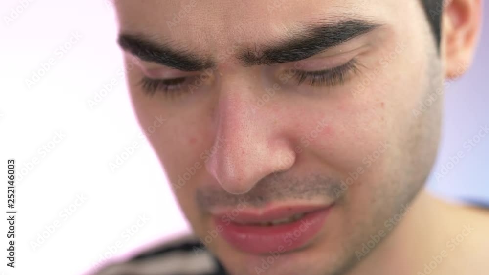 Young adult face showing regret and sadness emotions. Closeup. Young adult face showing regret and sadness emotions. Closeup.