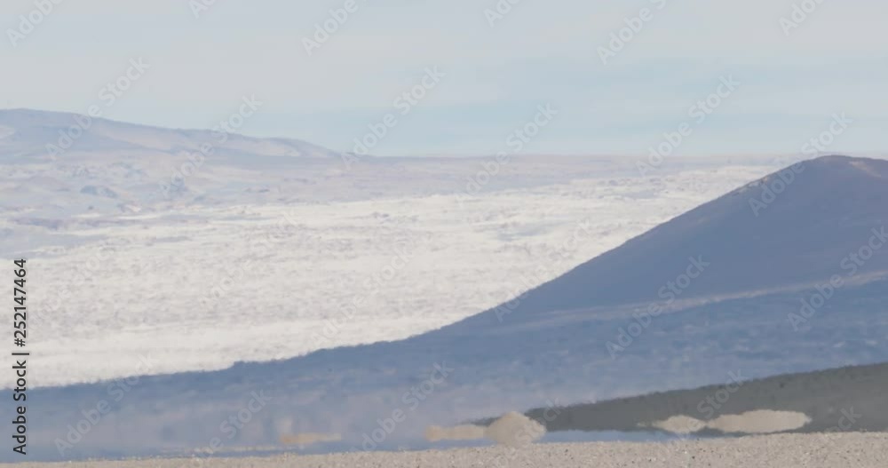 Close up of heat haze effect on desertic volcanic landscape. Black Carachi Pampa volcano at background. Antofagasta de la Sierra, Catamarca, Argentina Close up of heat haze effect on desertic volcanic landscape. Black Carachi Pampa volcano at background. Antofagasta de la Sierra, Catamarca, Argentina