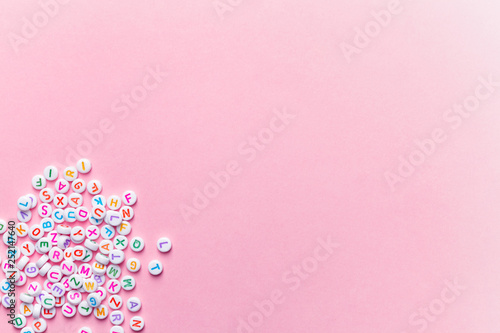 Obraz na plátně creative minimalist background, alphabet letter beads on pink, education concept