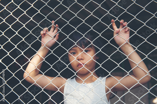  sad Asian girl child alone in cage was imprisoned make no freedom or lack of freedom