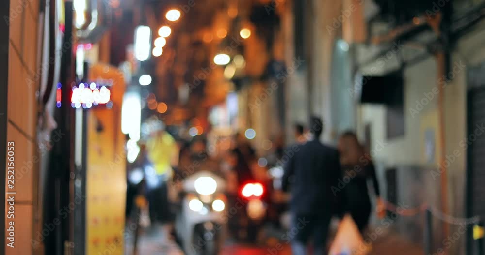 Absract Blurred Bokeh Night Traffic With Scooters And Bikes Urban Backdrop. Blurred Colorful Bokeh Background With Defocused Lights Of Narrow Street Absract Blurred Bokeh Night Traffic With Scooters And Bikes Urban Backdrop. Blurred Colorful Bokeh Background With Defocused Lights Of Narrow Street