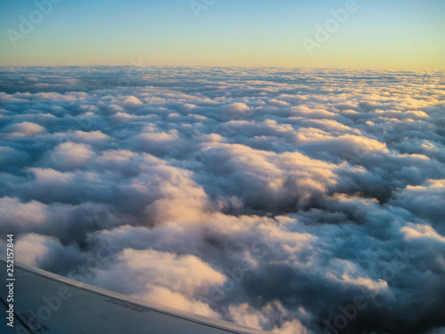 View from the airplane window. Beautiful view of airplane wing on blue sky and clouds © Rassul