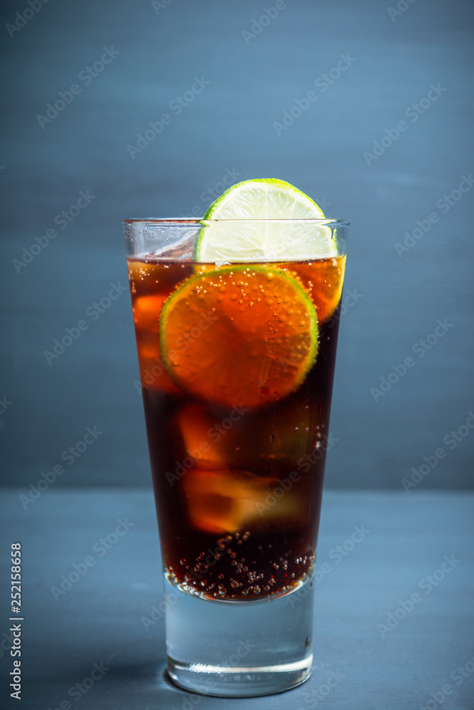 Cuba libre cocktail on the rustic background. Selective focus.