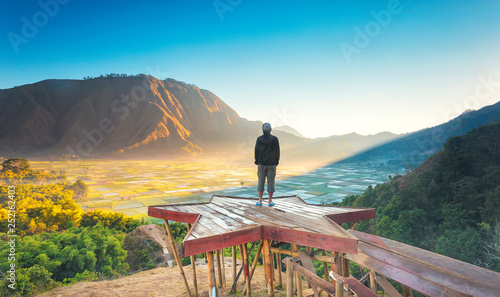 Traveller enjoying views wonderful farmland scenery at Sembalun near Rinjani volcano in Lombok, Indonesia. Traveling, freedom and active lifestyle concept. photo