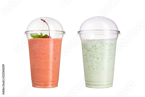 Delicious fruit smoothies in plastic cups, on a white background. Two cocktails with taste of cherry and milk.