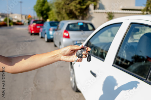 woman getting her key in the car. Concept of rent car or buying car.Travel vacation with rental car.travel with pleasure. learning to drive a car.Car key in hand.remote control car alarm systems.