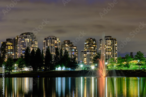 Wallpaper Mural Night scape city view, Coquitlam, Greater Vancouver area, Canada. Fountain in lake and water reflections of modern buildings windows lights Torontodigital.ca