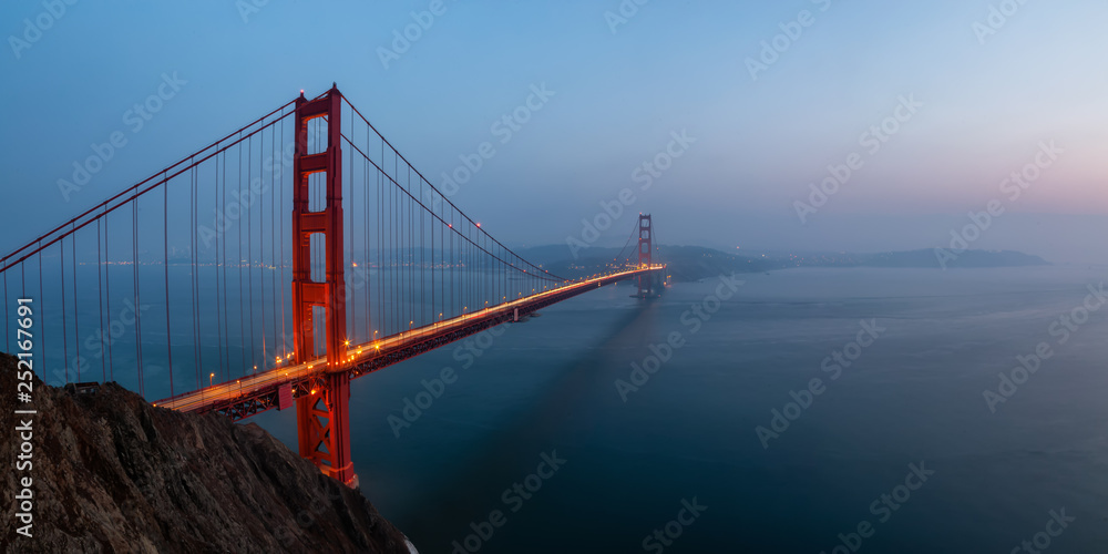 Fototapeta premium Beautiful panoramic view of Golden Gate Bridge during a hazy sunset. Taken in San Francisco, California, United States.