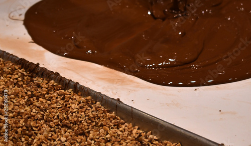 Fototapeta Naklejka Na Ścianę i Meble -  chocolate being poured next to almonds