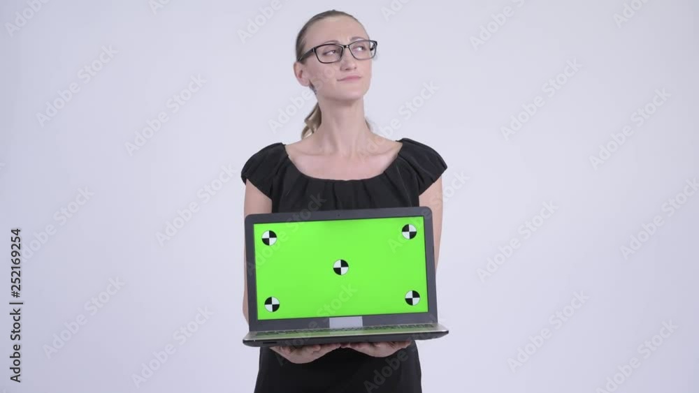 Happy blonde businesswoman thinking while showing laptop Happy blonde businesswoman thinking while showing laptop