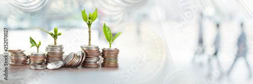 Double exposure of Financial planning, Money growth concept. Coins with young plant on table with backdrop blurred of nature, with white blurred of people walking in city town.