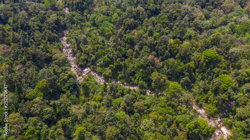 Drone landscape of rocky river stream flowing through Thai jungle forest