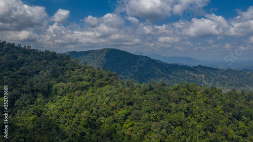 Green slopes of the Southern Thai hills with mountainous perspective and cloudy blue sky © Alexander Zvarich 