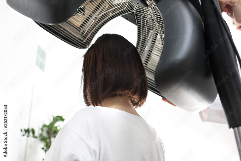 Obraz premium Pielęgnacja włosów . Kobieta podczas zabiegu pielęgnacyjnego na włosy w salonie fryzjerskim.