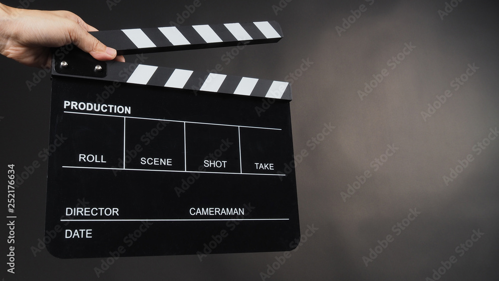 Hand's holding Clapperboard or movie slate use in video production ,film, cinema industry on black background.