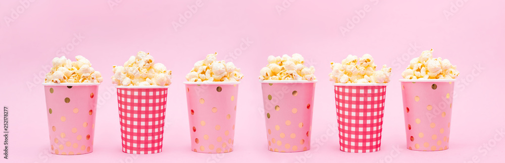 several cups of popcorn on a pink background several cups of popcorn on a pink background