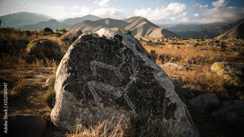 Foto Rock painting aka petroglypgs at the field in Cholpon-Ata, Issyk-kul, Kyrgyzstan