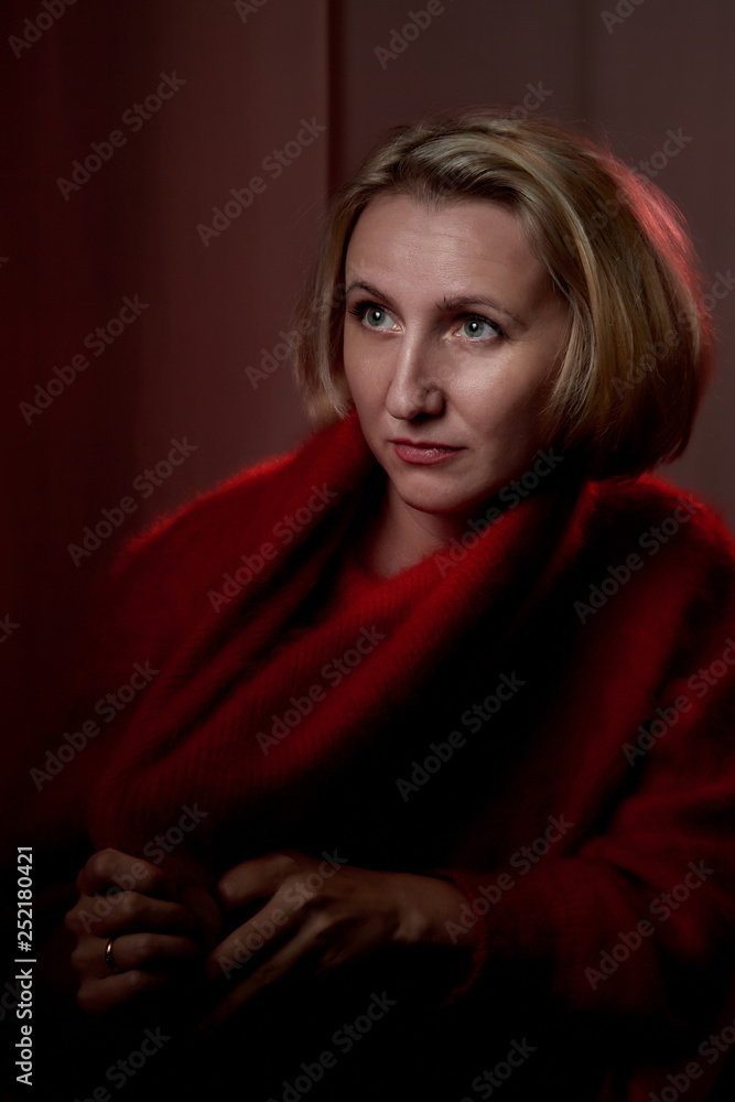Portrait of a middle-aged woman in the room. Photography in the Studio. Photo shoot in a dark key Portrait of a middle-aged woman in the room. Photography in the Studio. Photo shoot in a dark key