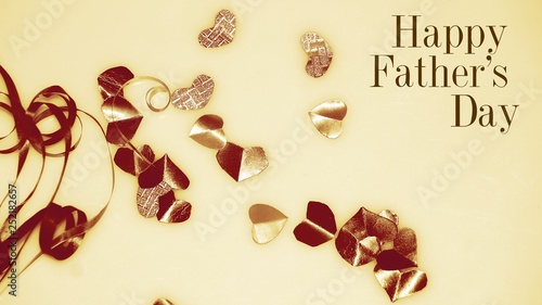 Happy Fatther's Day words with Colourful heart shape ribbon and small gift boxes on colorful bokeh, flare background. Image noise and light leaks.