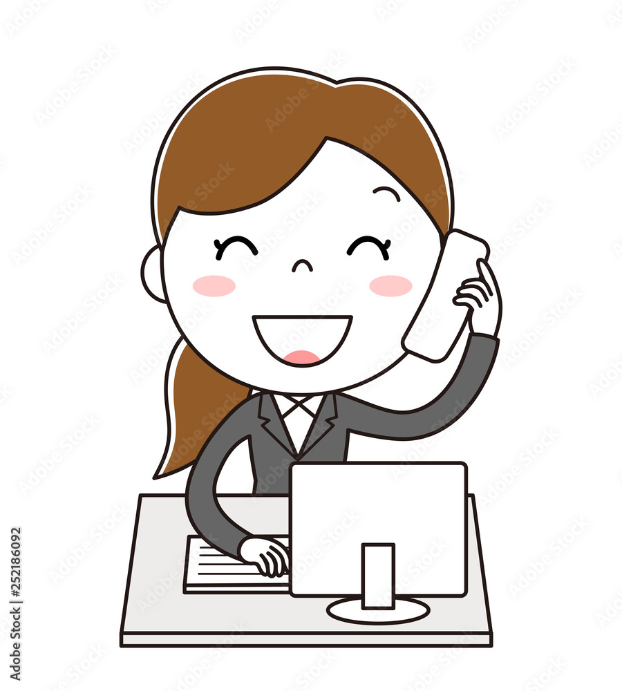 デスクトップパソコンの前で電話対応をしている笑顔の女性社員