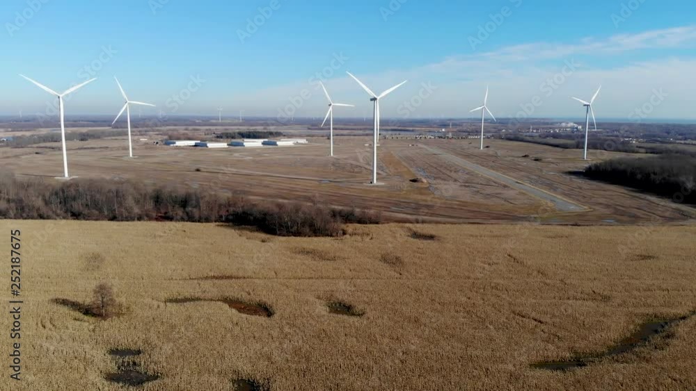 Wind turbines in winter farmer's fields in Canada. Drone aerial shot