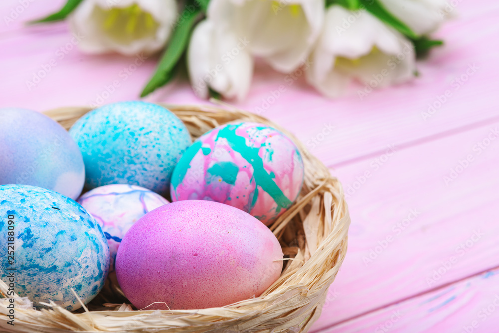 Easter background with colorful eggs and tulips over pink wood. Top view with copy space Easter background with colorful eggs and tulips over pink wood. Top view with copy space