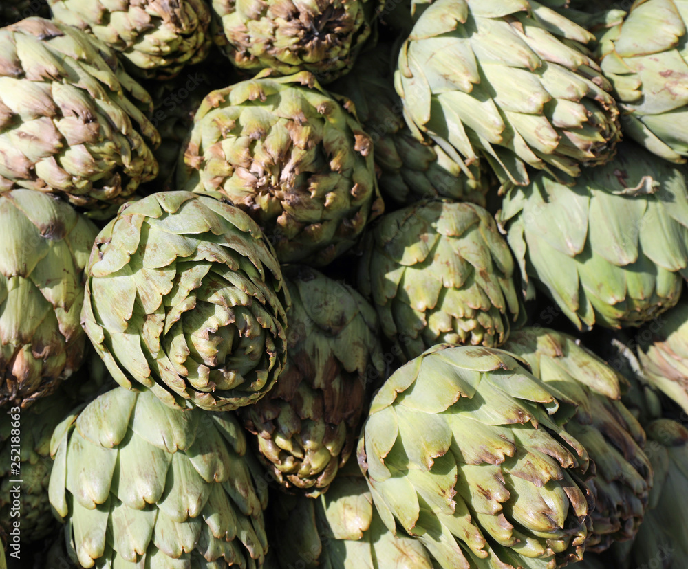 Fototapeta premium background of green ripe artichokes in the supermarket fruit and
