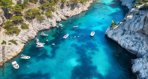 Yachts in sea bay in France. Aerial view of luxury floating boat on transparent turquoise water at sunny day. Summer seascape from air. Top view from drone. Travel concept and idea