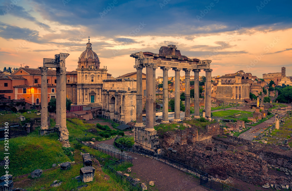 View of the temple of Saturn in Roman forum, Italy. Ruins of Septimius Severus Arch and Saturn Temple. Rainbow over the Roman forum. Rome architecture and landmark.