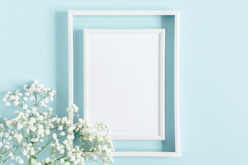Flowers composition romantic. White gypsophila flowers, photo frame on pastel blue background. Valentine's Day, Easter, Birthday, Happy Women's Day, Mother's day. Flat lay, top view, copy space