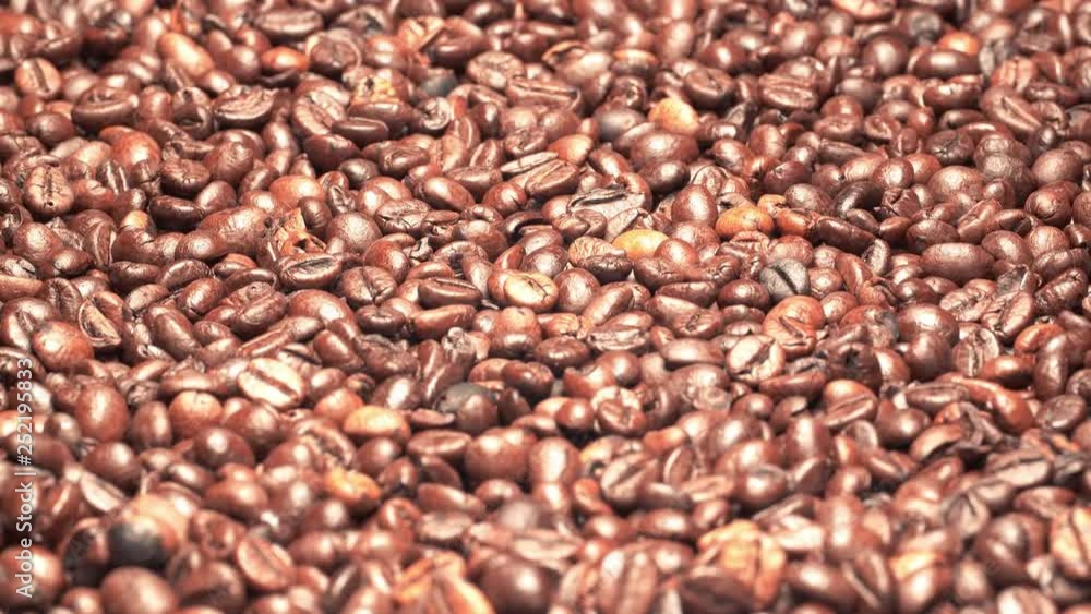 UHD graded closeup shot of the dark roasted coffee beans on a turntable UHD graded closeup shot of the dark roasted coffee beans on a turntable