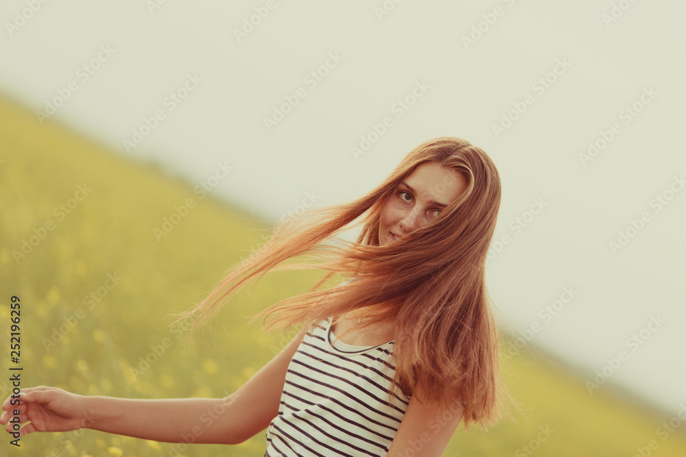 Portrait of a beautiful girl in a field with yellow flowers, summer, sunset Portrait of a beautiful girl in a field with yellow flowers, summer, sunset