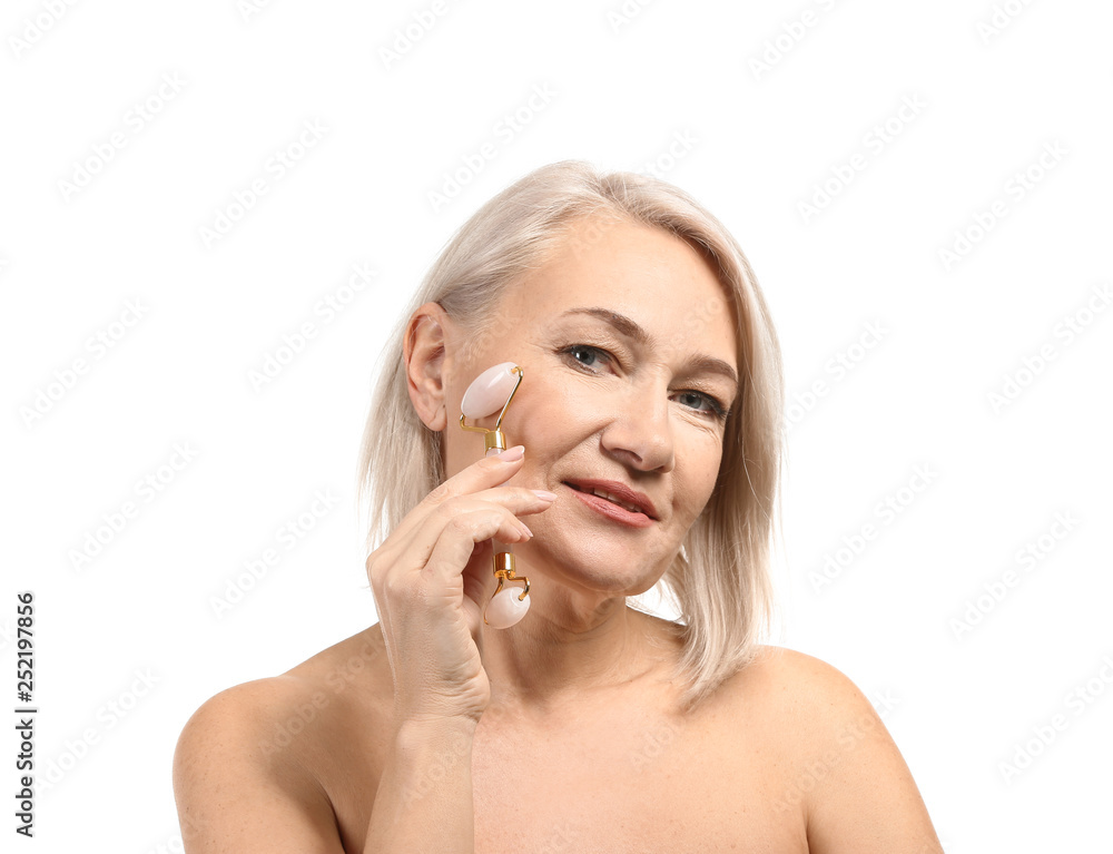 Mature woman with facial massage tool on white background Mature woman with facial massage tool on white background
