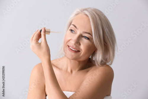 Mature woman applying face ...